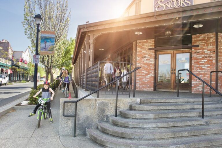 Cyclists passing Snooks’ brick storefront on Sutter Street in Historic Folsom, California